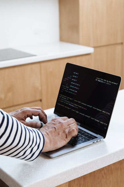 The image displays a close-up of a laptop screen showing a code editor with JavaScript and HTML code. The code is highlighted in various colors indicating syntax, with visible tags such as <img src>, 
